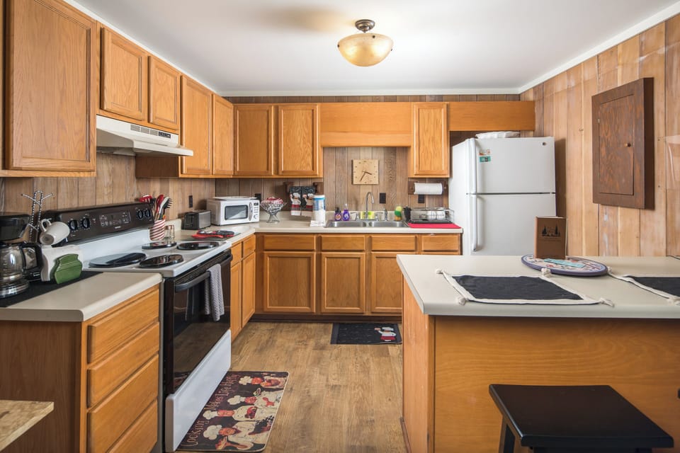 Cozy kitchen with full amenities and warm wood cabinetry.