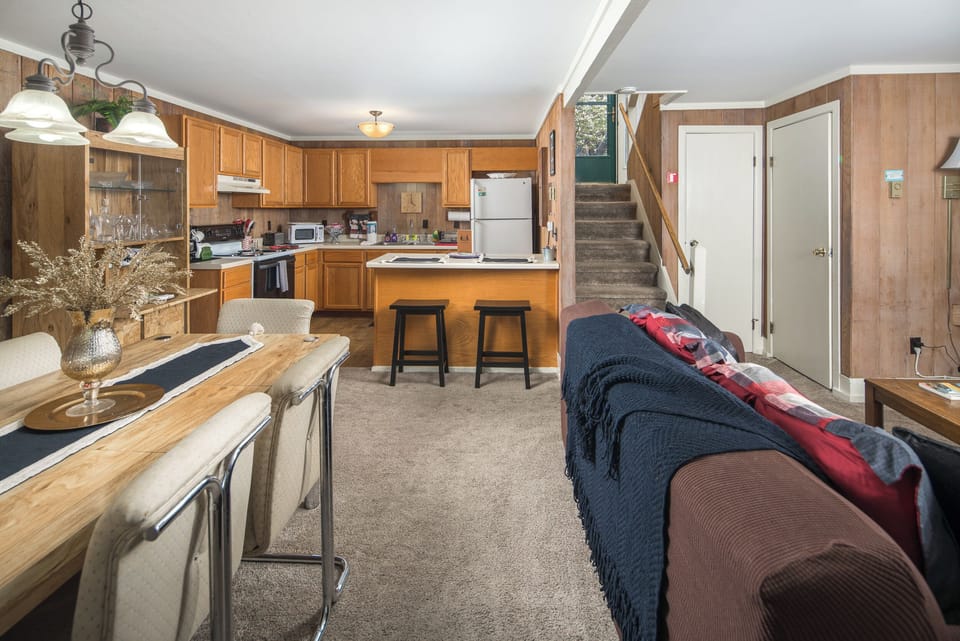Open kitchen, dining nook, and upper entry with wood finishes.