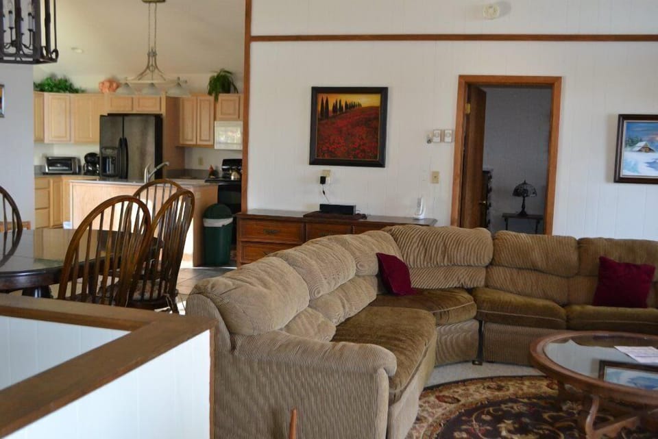 Stylish space with sectional sofa, dining area, modern kitchen, and framed pictures.