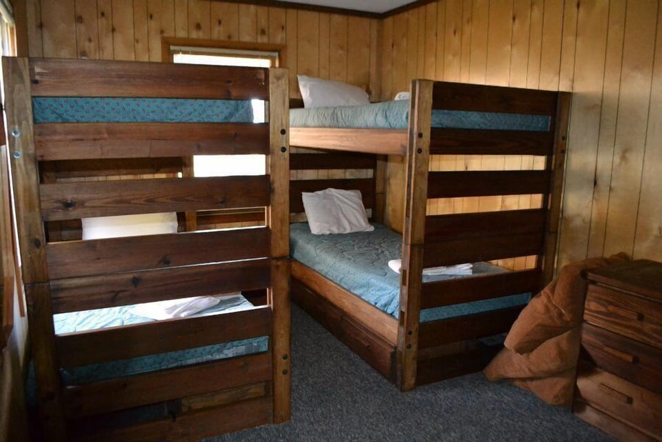 Wooden interiors, blue bedding, and twin bunk beds create a cozy, adventurous space.