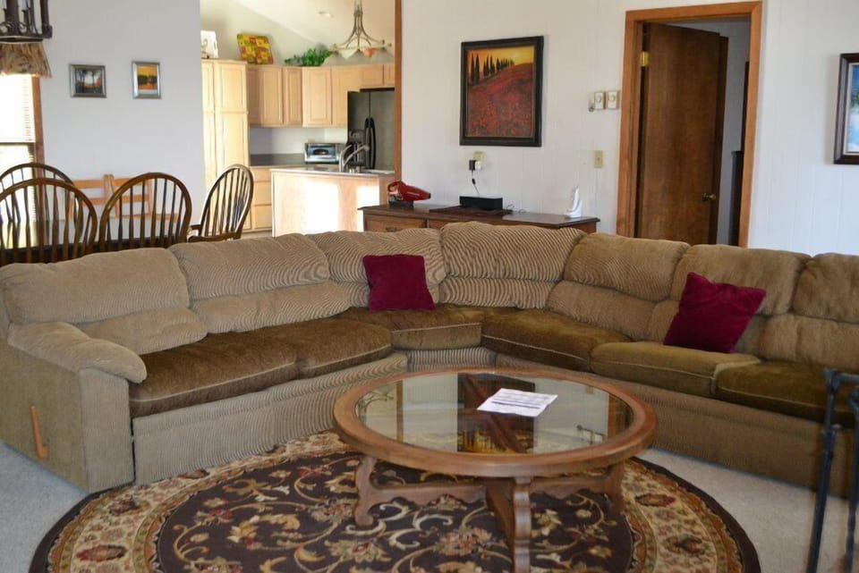 Cozy living space with plush sofa, glass-top table, and warm lighting.