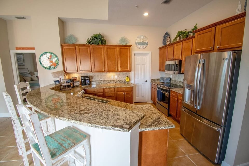 The spacious, well-appointed kitchen is perfect for family meals. Enjoy a quick bite at the bar or a full meal at the handcrafted dining table, designed for comfort and style.