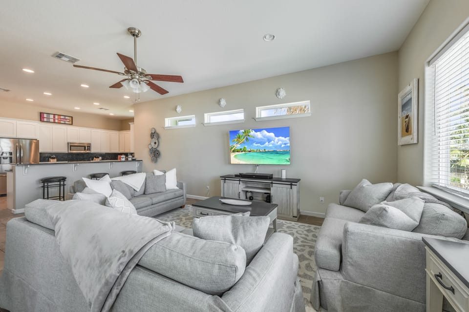 Sink into plush gray sofas and enjoy movie nights on the large screen TV in this bright, open living space.