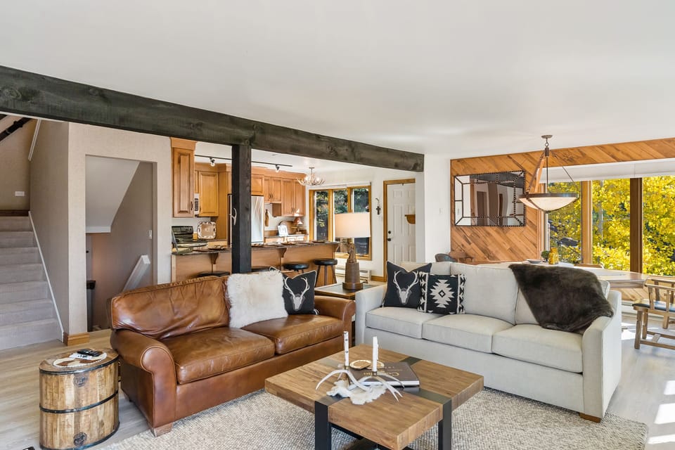 Picture taken from the back corner of the living room showing the entire living space, including kitchen, living room, and dining room.