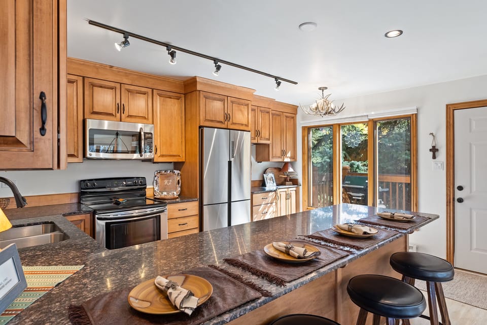 Bar with seating for 4 at the kitchen peninsula. Stainless steel appliances and high end wood cabinets.