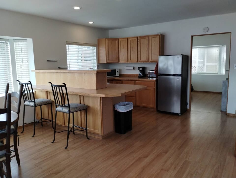Waterfront Cabin – Kitchen Equipped with Fridge, 12-Cup Drip Coffee Maker, Toaster, Microwave, 4-burner stove with Oven, Tea Kettle, Coffee, Creamer, Sugar, Tea, Filters, and Basic Cooking Essentials.