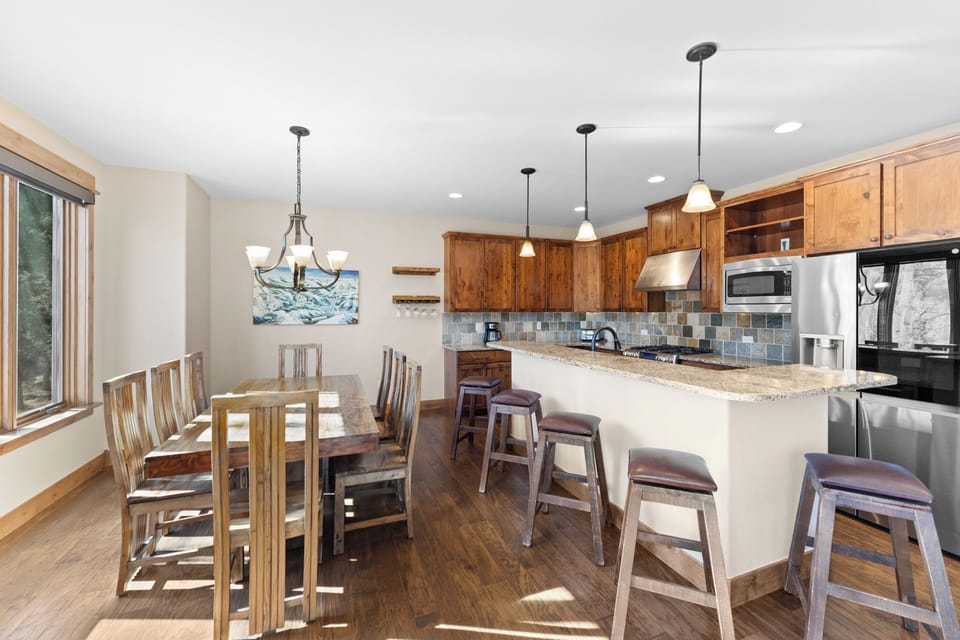 Gather around the spacious kitchen island with granite countertops and modern appliances, perfect for cooking together and sharing memorable meals.