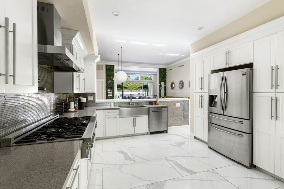 Cook with ease in a stylish kitchen designed with crisp white tones and stainless finishes.