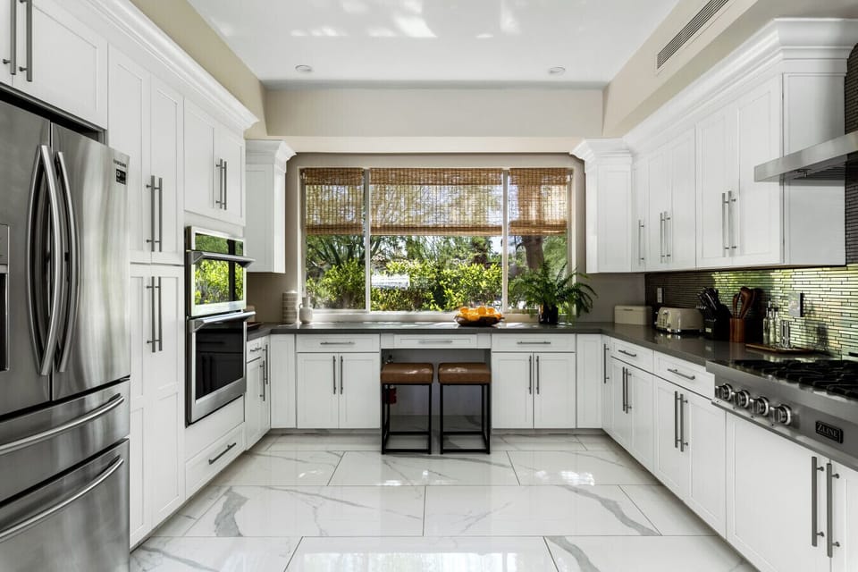 A bright white kitchen with sleek metallic appliances for a clean, modern feel.
