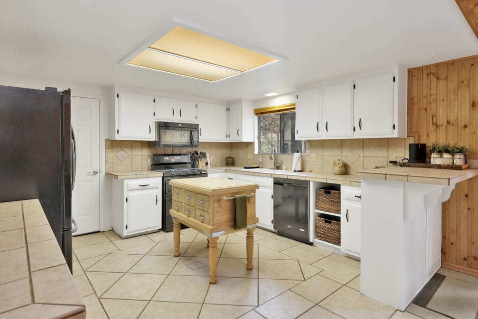 Fully equipped cabin kitchen with ample cabinetry, stove, fridge, microwave, and coffee maker—perfect for cooking meals, morning coffee, and feeling right at home on your stay.