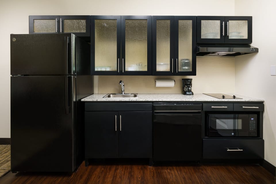 Prepare simple meals with full-size fridge and modern cabinets.