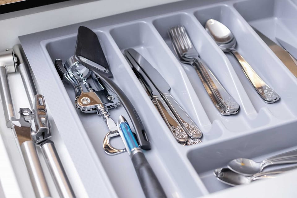 A drawer with neatly organized cutlery, ensuring functionality for guests.
