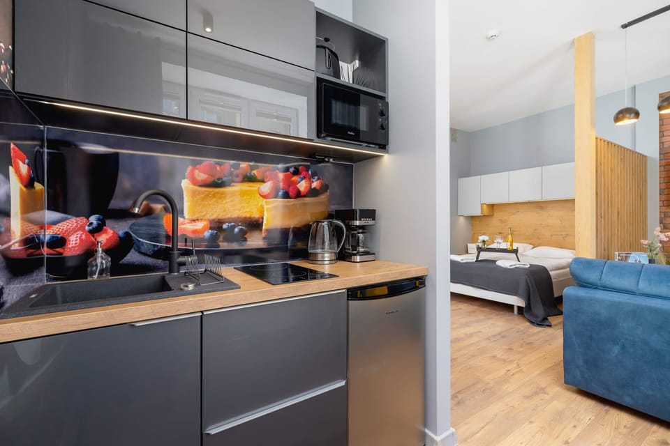 A sleek kitchen with black cabinetry, modern appliances, and a glossy backsplash for a contemporary look.
