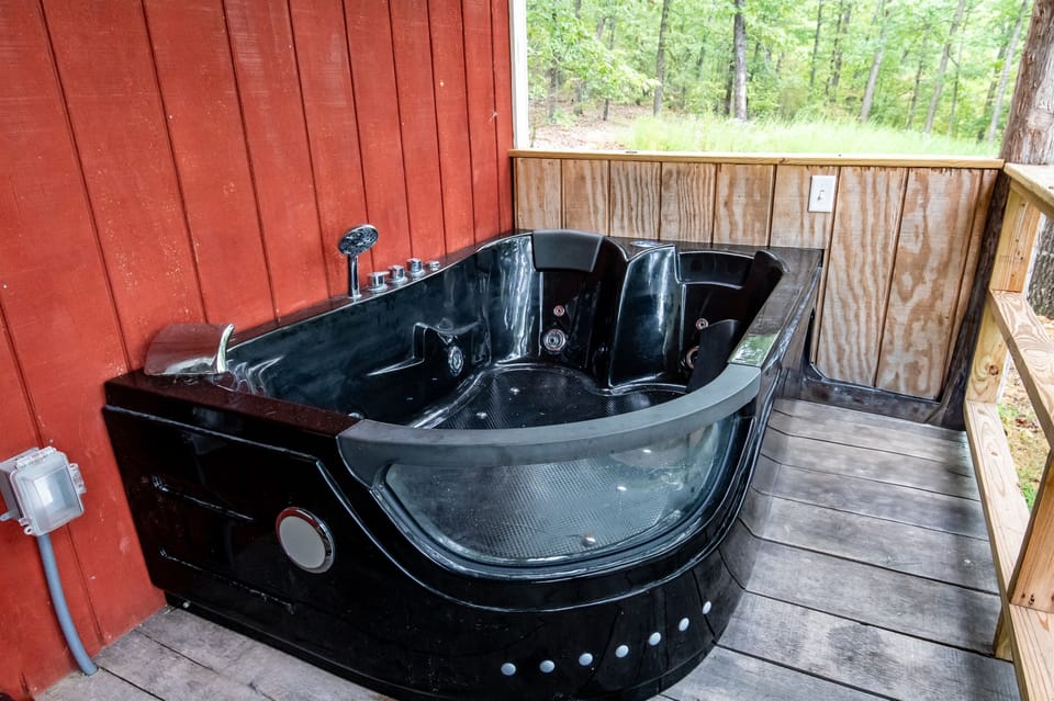 -  Jacuzzi tub with relaxing forest views   - Unwind in a private corner surrounded by trees   - Serene experience perfect for a couple  wanting a cabin retreat