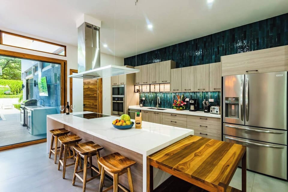 Spacious vacation home kitchen featuring a stylish counter and top appliances, designed for comfort during your Tamarindo stay.