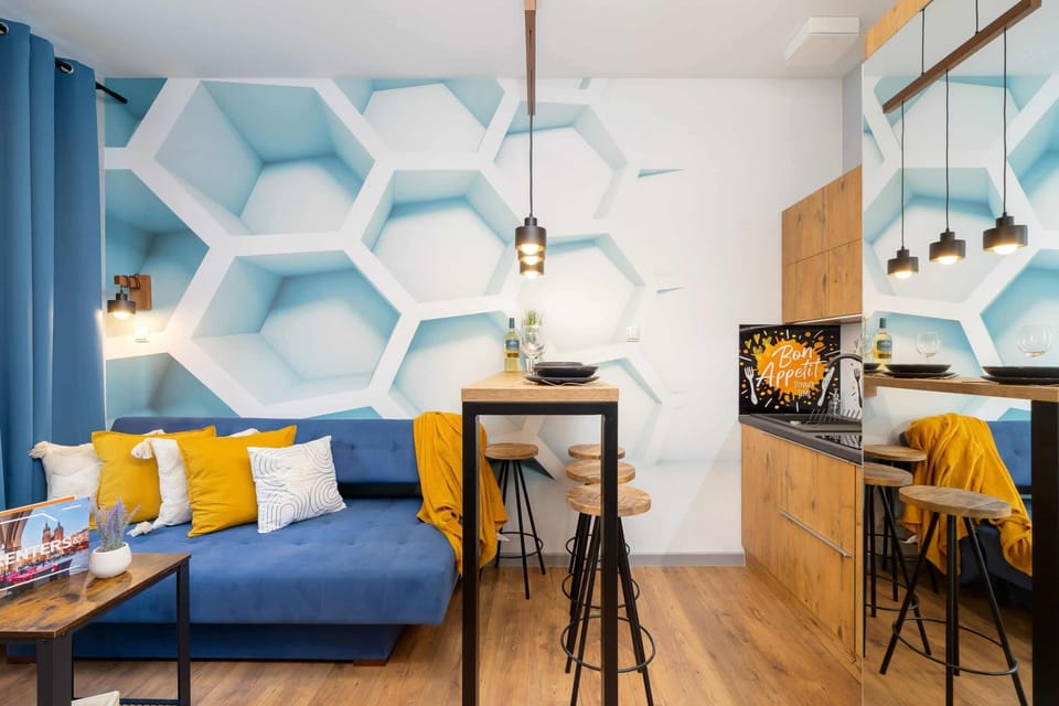 A wide view of the open-plan living space with blue and yellow accents, showcasing its vibrant and harmonious design.
