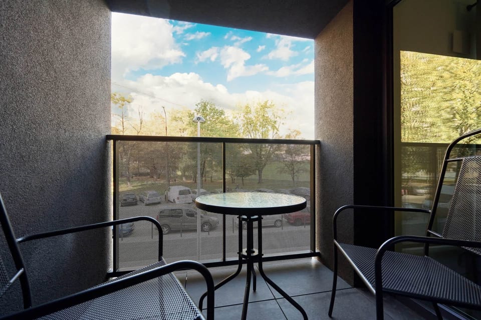 A private balcony with a small table and chairs, offering a peaceful spot for enjoying the outdoors.
