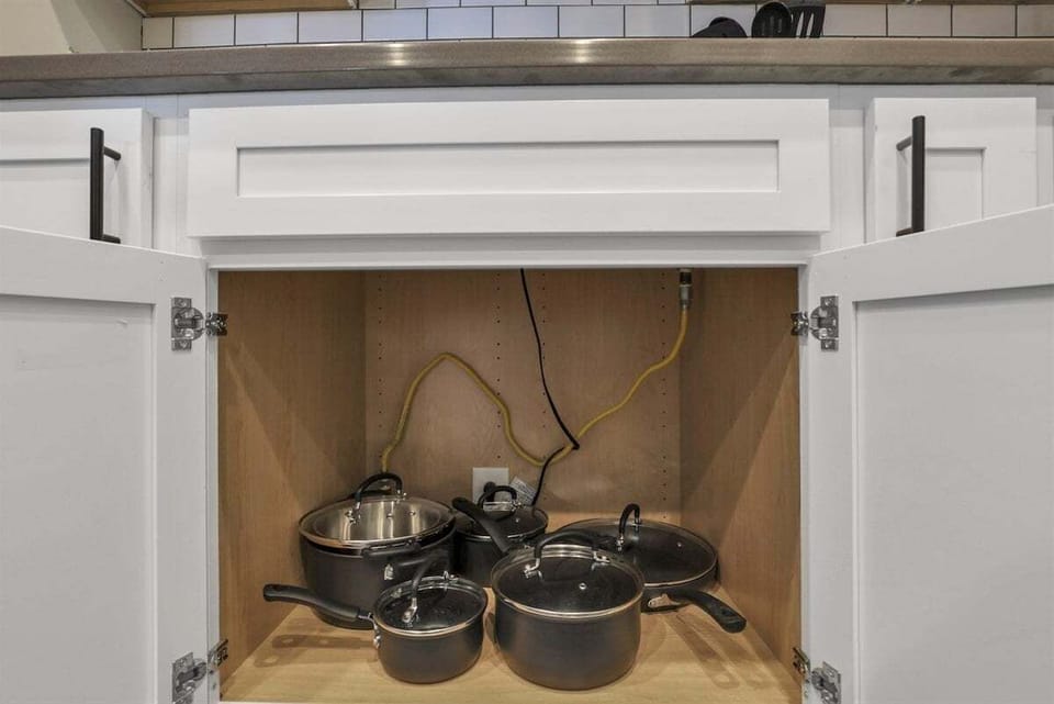 A lower cabinet holding cookware ready for home-style meals.