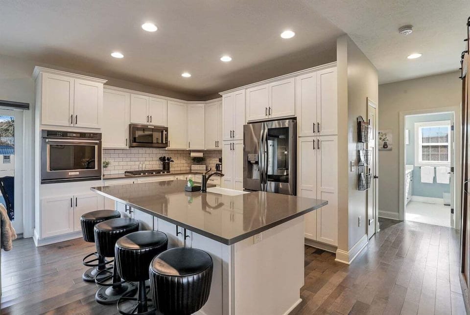 A bright kitchen featuring a large island with barstool seating.