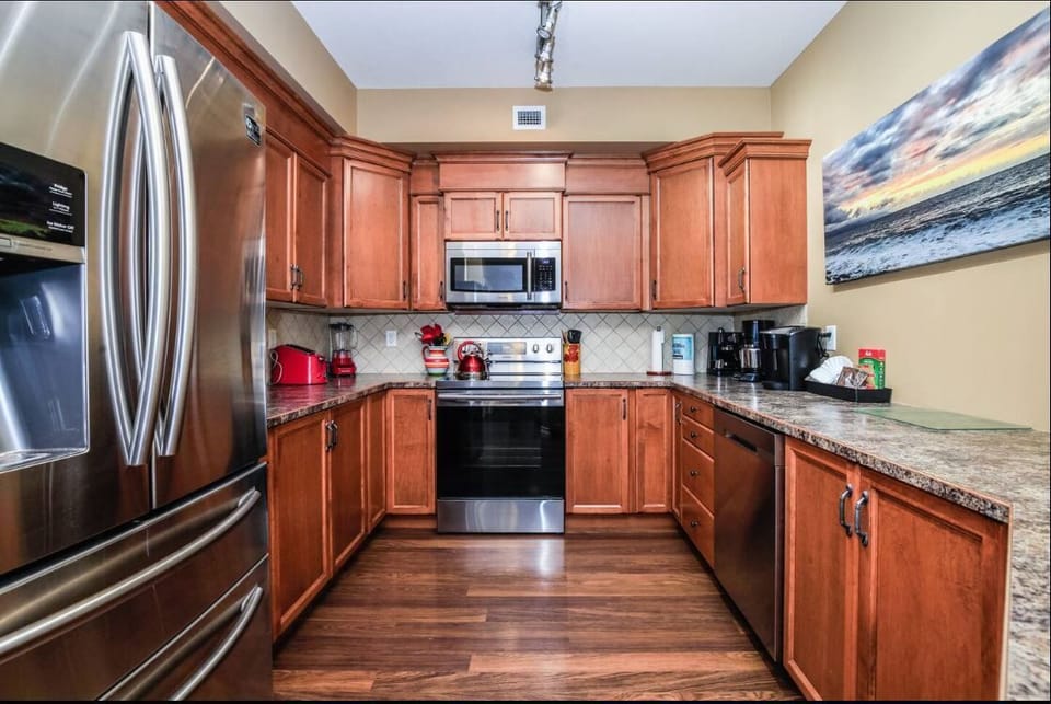 This kitchen has gorgeous wooden cabinets, electric stove-top and dishwasher.