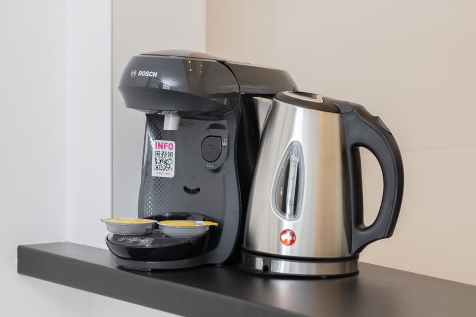A coffee station with a kettle and cups, ensuring guest convenience and comfort.
