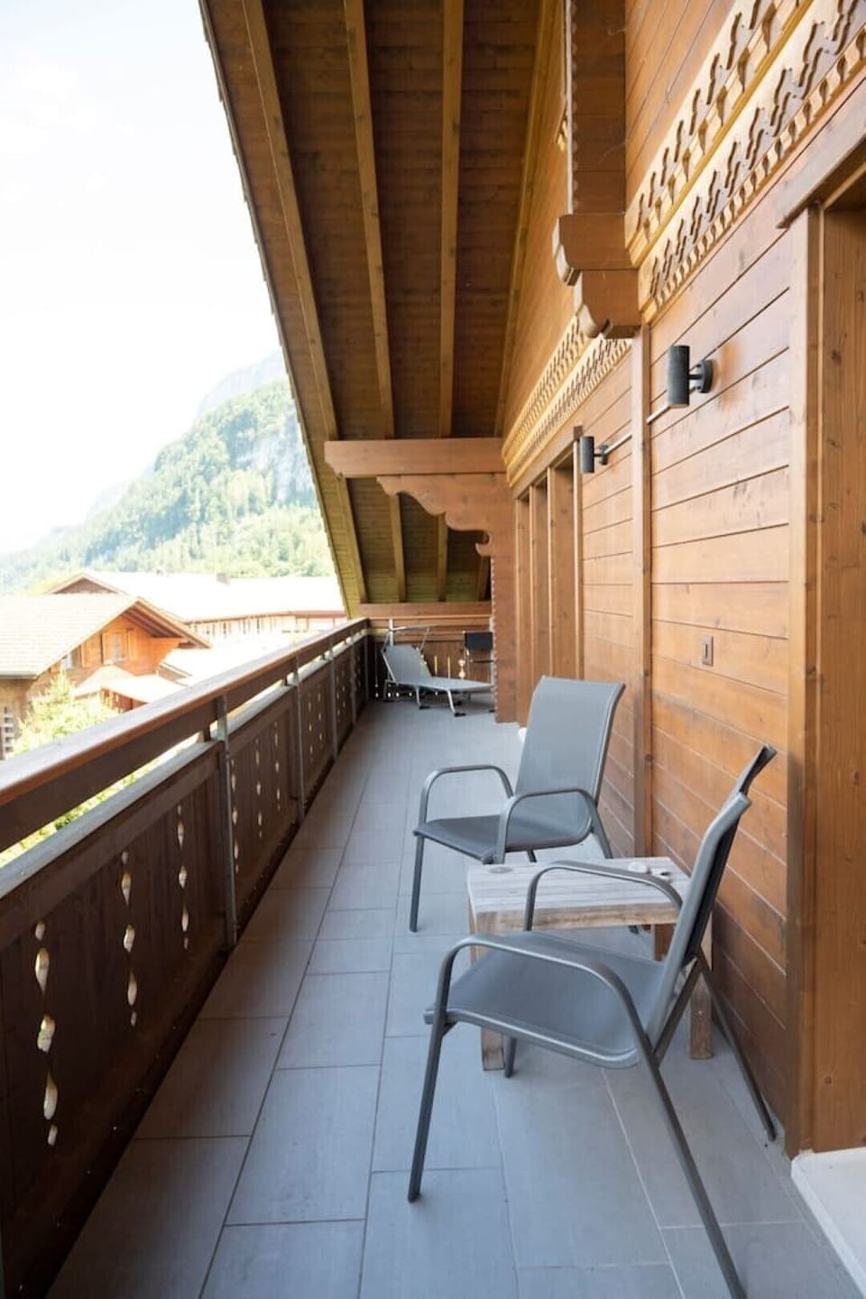 North facing balcony with two sun lounges and chairs with lake view. 