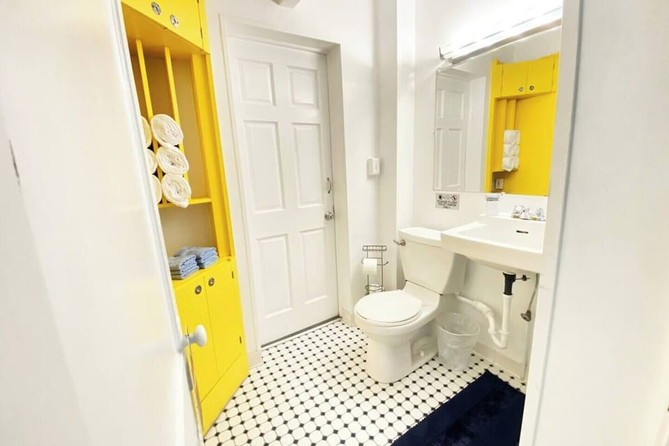 The retro bathroom is decorated with fun subway tiles and new cabinets, and leads directly out to the back porch, where there is a washer and dryer.