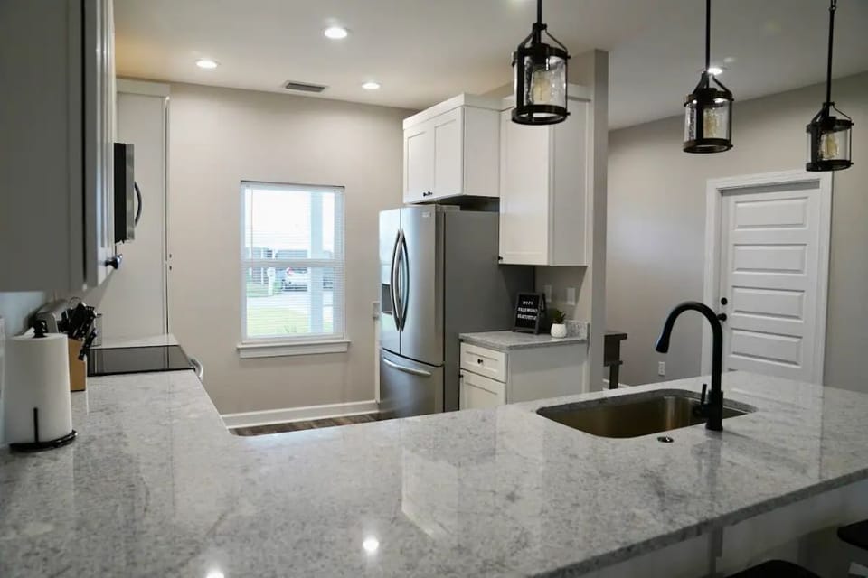 Fully stocked kitchen with stainless steel appliances and granite counters.