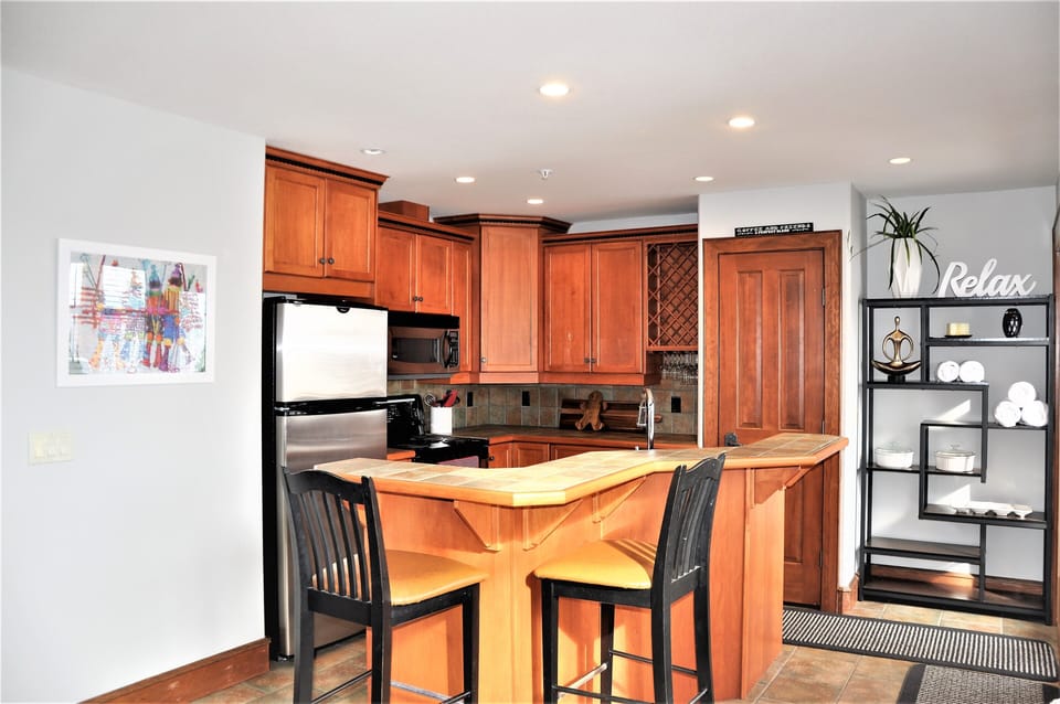 Open kitchen with stainless appliances, wine rack and bar seating.