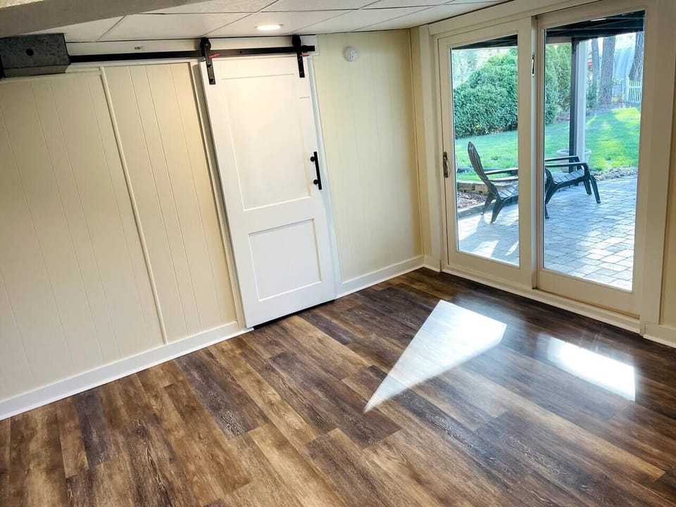 Basement access to the back yard through the sliding door, and access to the laundry room through the barn door.