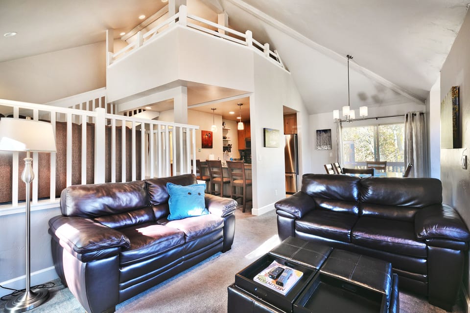 - Spacious living room with open loft design and cozy fireplace  
- Comfortable seating perfect for group gatherings or relaxation  
- Easy access to kitchen and dining for shared meals together