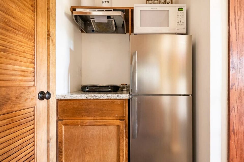 A small refrigerator, microwave, and hot plate for cooking and food storage needs