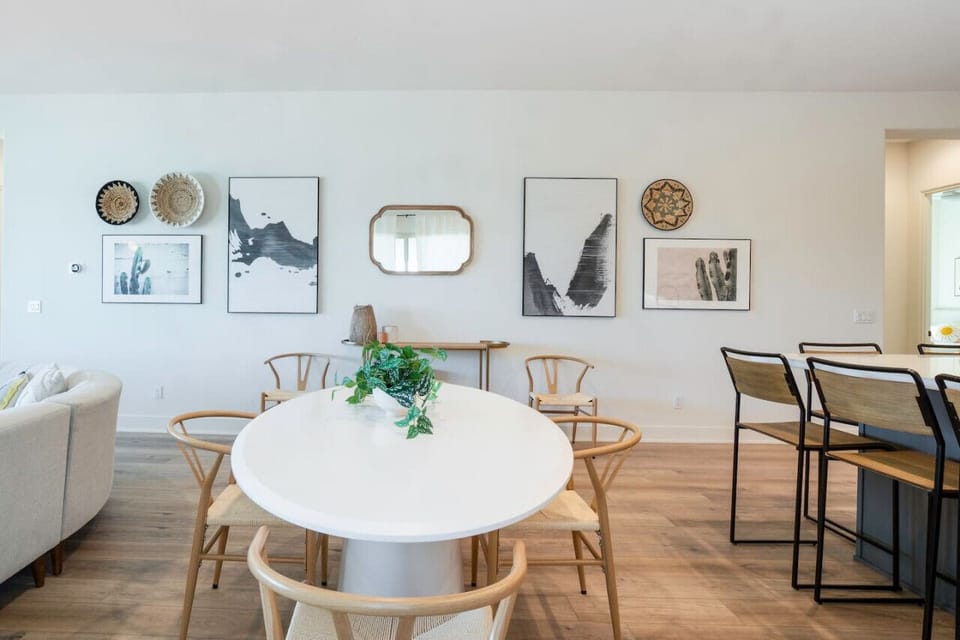 Dining area w/ round table & wall art, perfect for casual meals & conversation