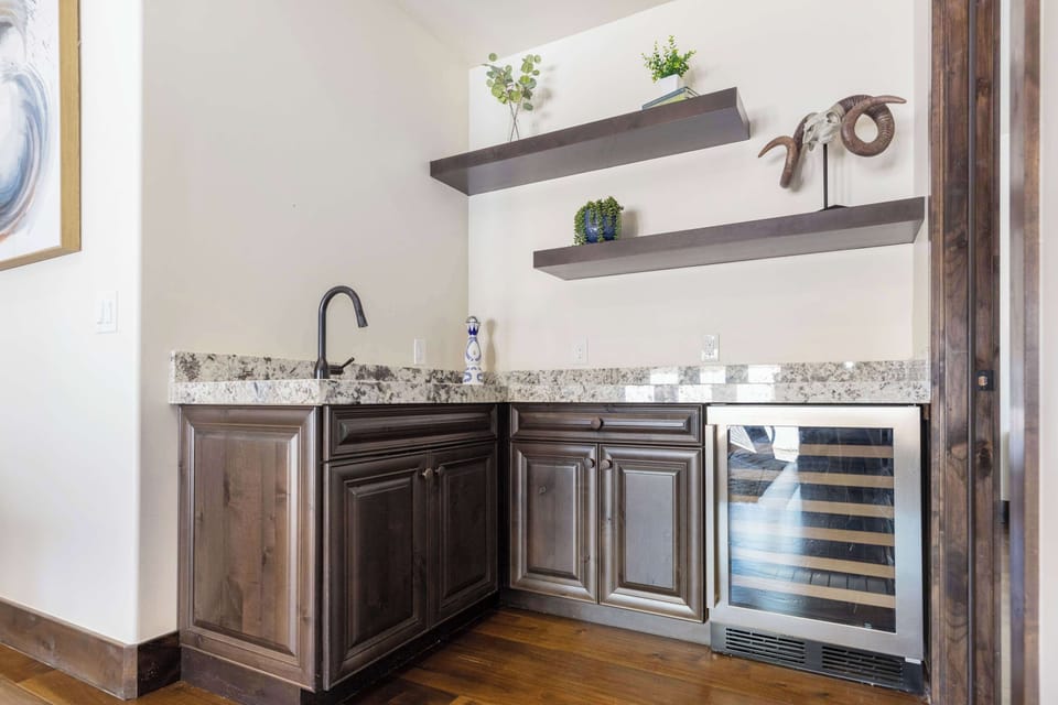 Unwind at your sleek private bar, complete with a wine cooler and sink.