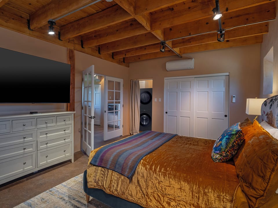 Bedroom with Large Screen HDTV and stackable LG washer/dryer