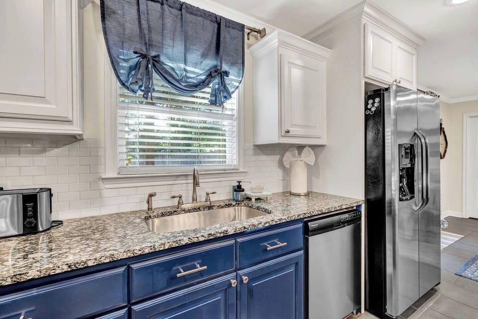 This vibrant kitchen combines charm and convenience with sleek granite countertops, a full suite of appliances, and bold two-tone cabinetry. Imagine morning coffee by the window or cooking up dinner while laughter fills the home.