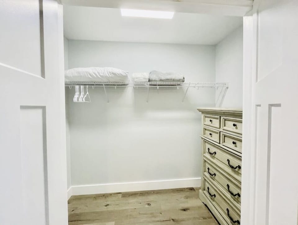 Inside Of Large Walk-In Closet With Five Drawer Chest Inside