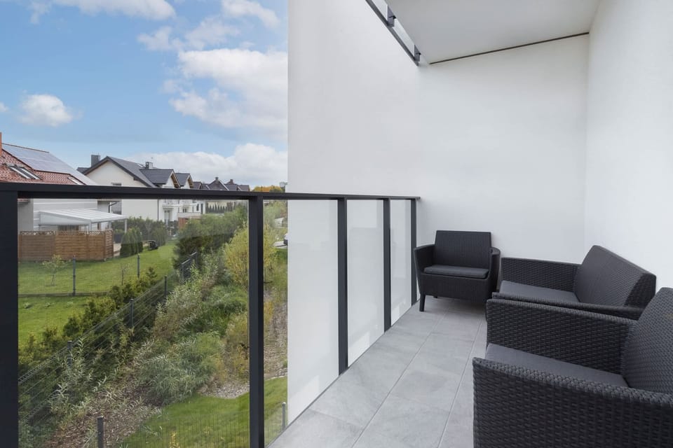 Another balcony view showing outdoor furniture and a lush green landscape.
