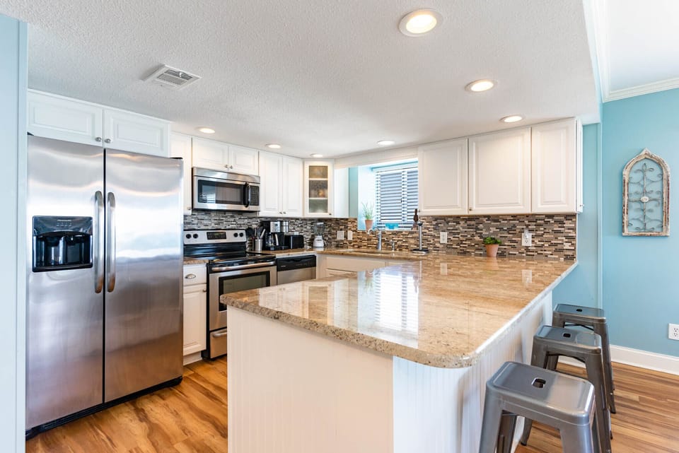 Your gourmet kitchen awaits with gleaming granite counters, stainless appliances, and breakfast bar seating—perfect for morning coffee or evening meals.