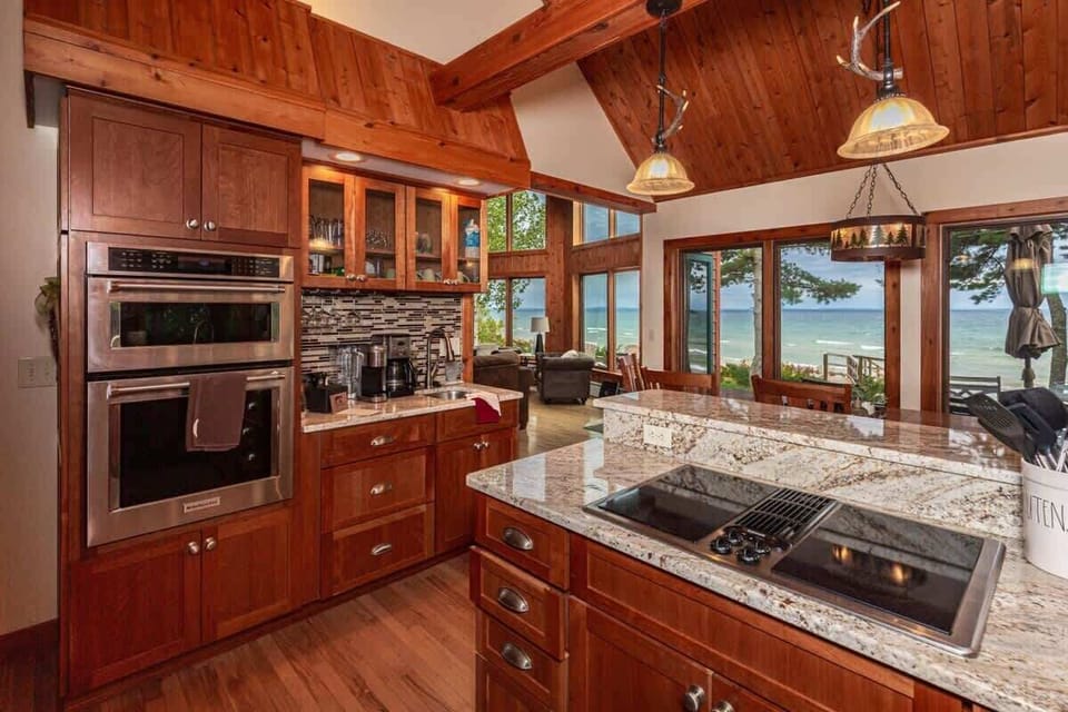 Fully equipped kitchen with stainless appliances and Lake Superior visible right outside the window — the best view you'll have while doing dishes