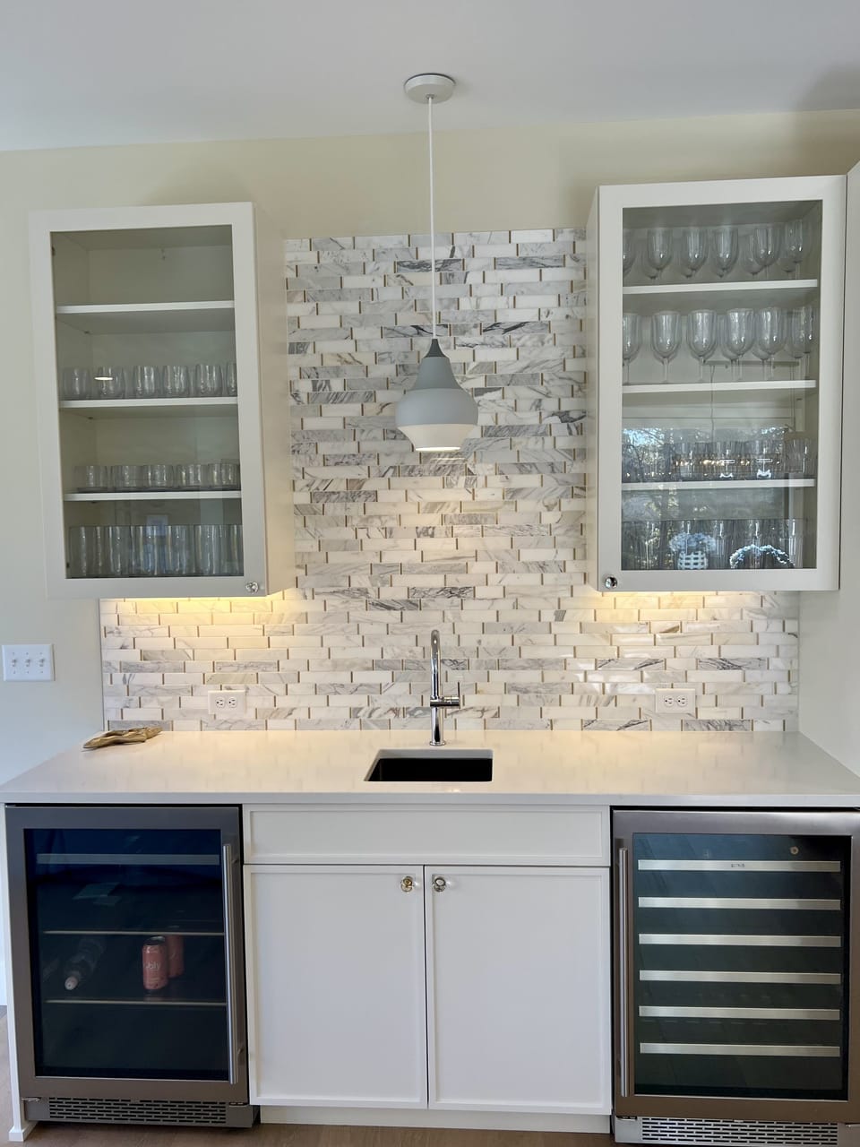 Wet bar with quartz counters, marble backsplash and wine & beverage refrigerator