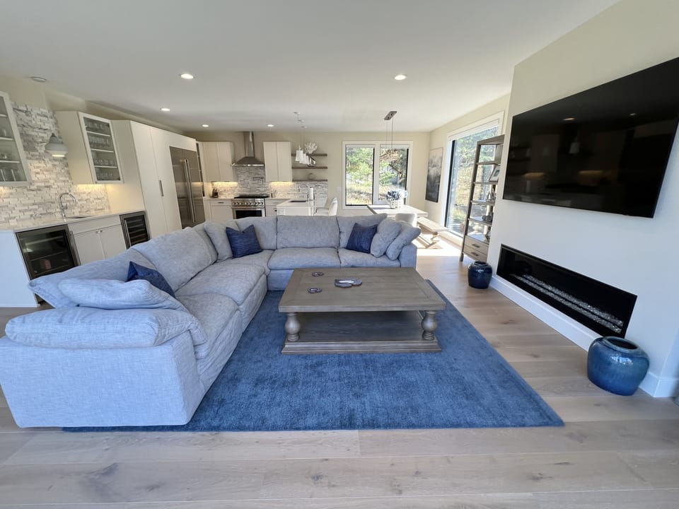 Main living area w/ Restoration Hardware sectional, flat-screen TV and fireplace