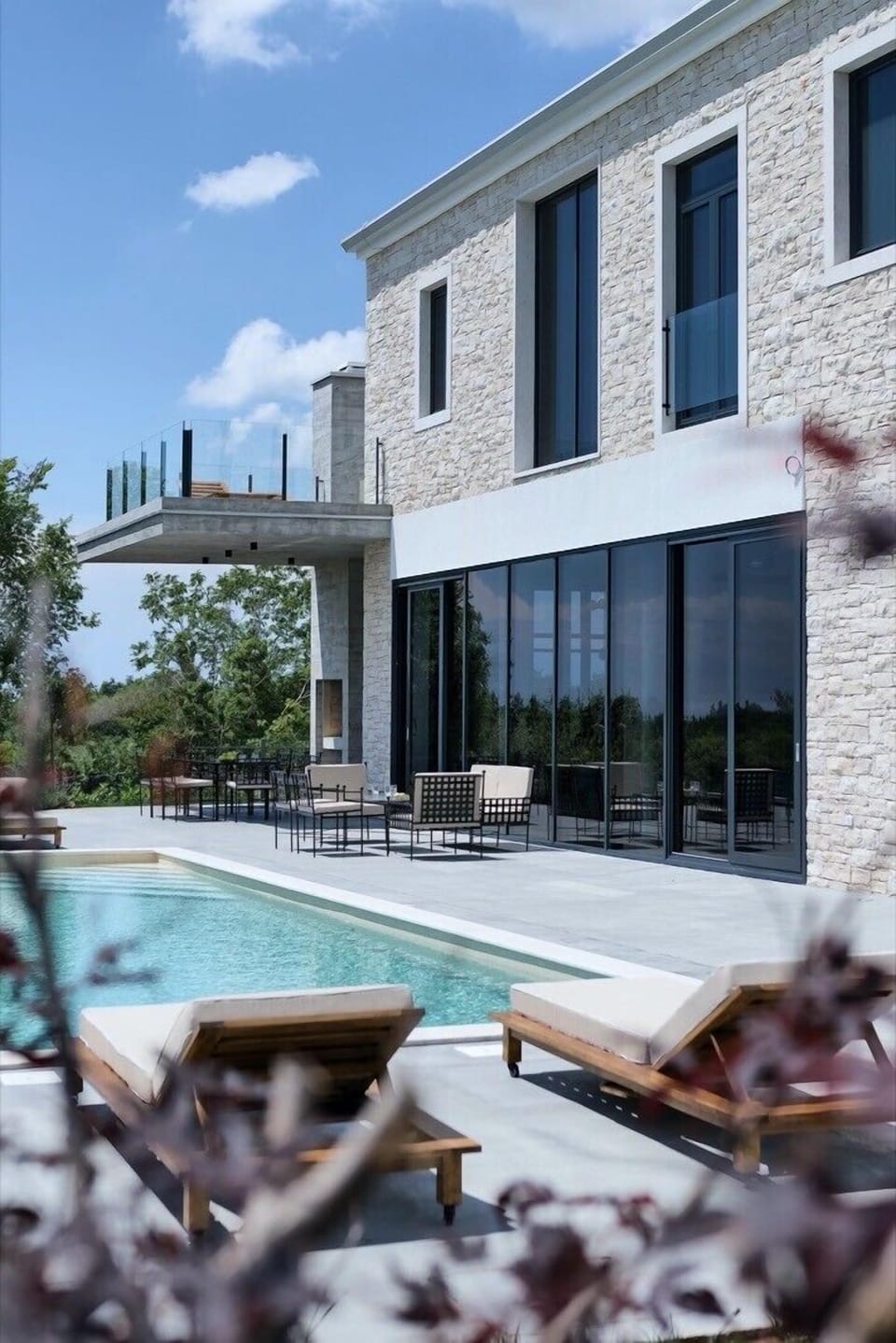 Sunbathing area near pool in luxury villa Valens Residence for family vacation and rent.