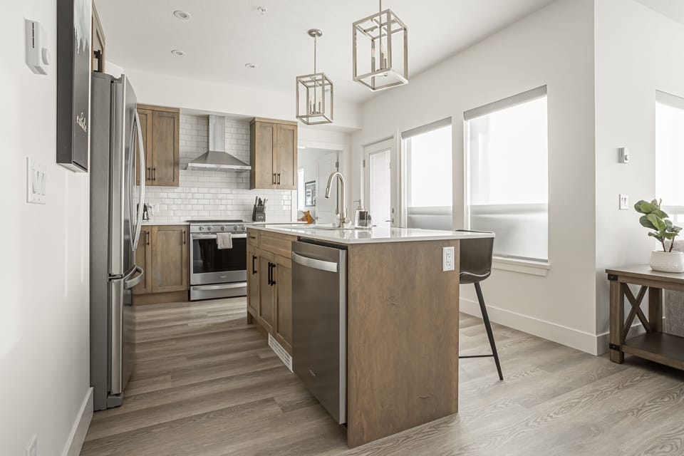 Gourmet kitchen with quartz counters, stainless appliances & pendant lighting