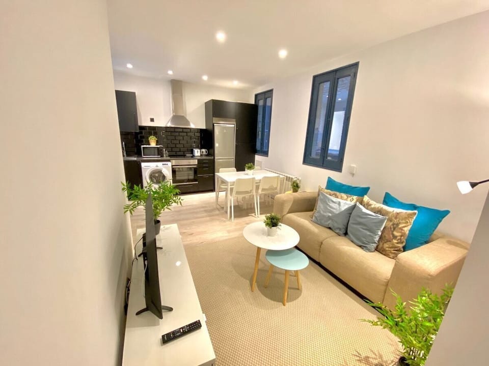 General view of the living room with kitchen in the background
