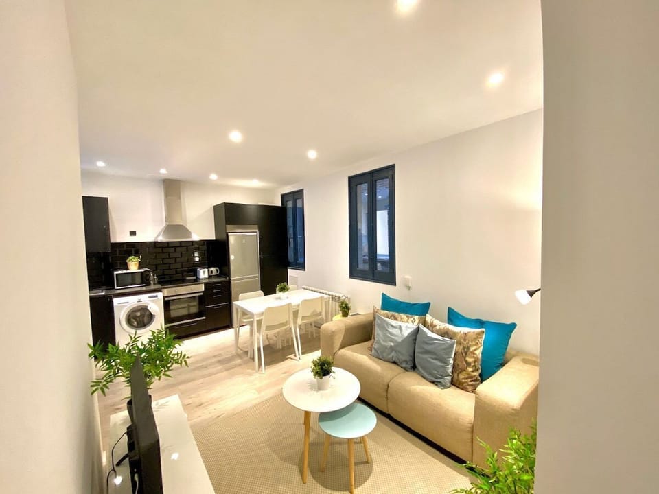 General view of the living room with kitchen in the background