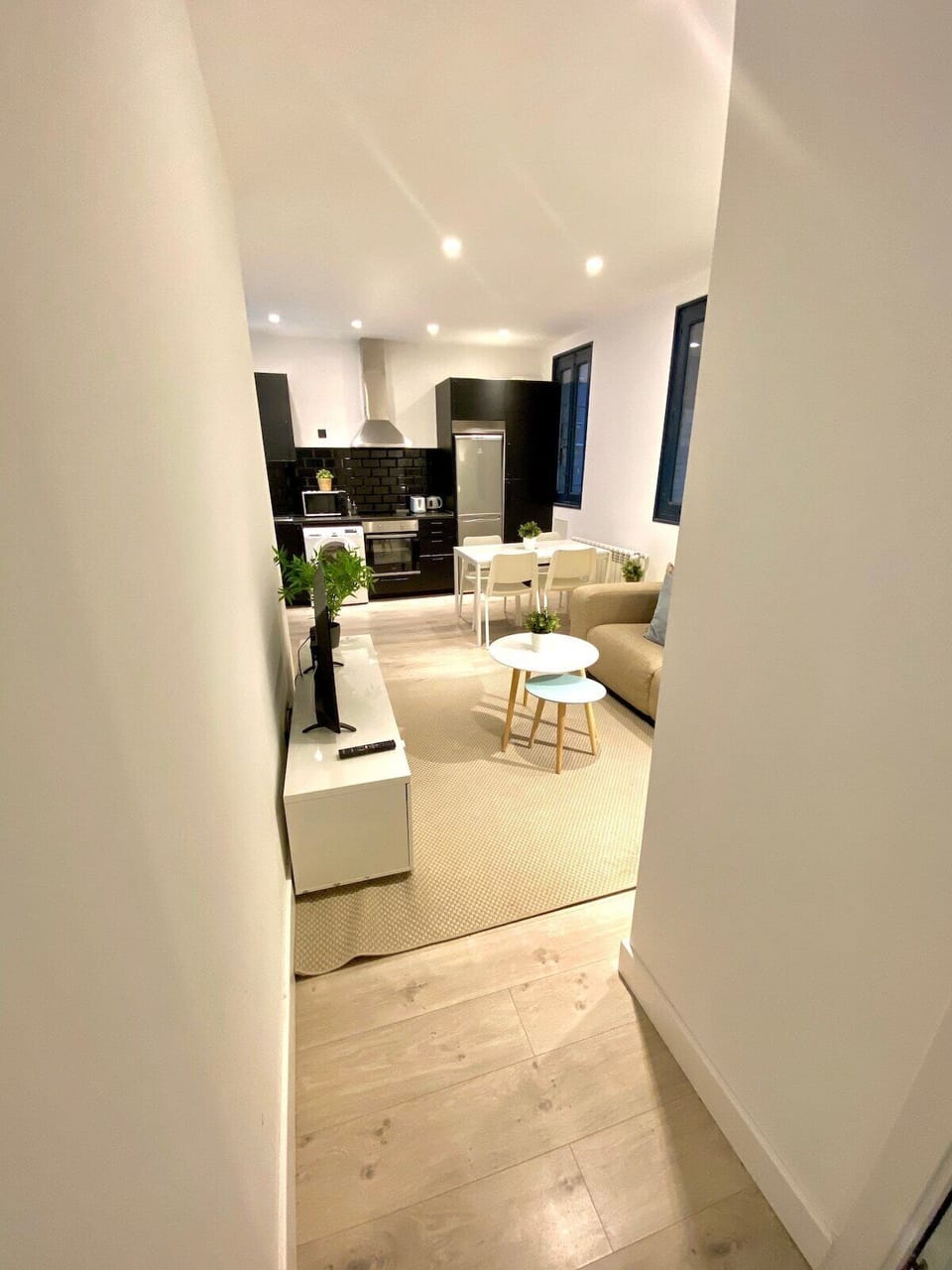 General view of the living room with kitchen in the background