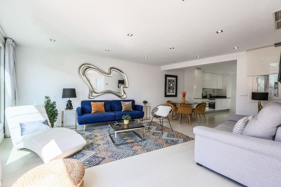 Main view of the living-dining room space and the kitchen in the background