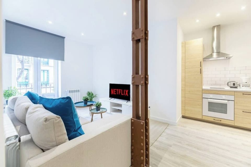 General view of the living room with access to one of the balconies and the kitchen in the background