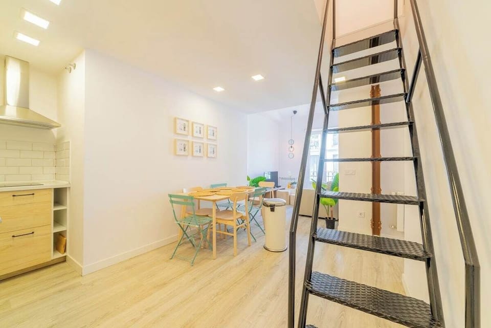 General view of the living room with access to the balcony and stairs to the upper bedroom